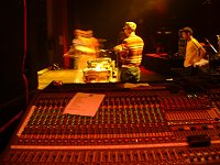 DJ on stage, seen from behind monitors desk