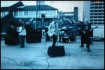 Video still: The band playing on a roof top