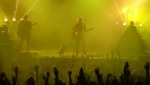 The band bathed in yellow and green lights